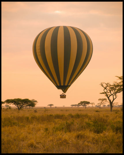 Ein Leinwandbild von einem Heißluftballon, der über der afrikanischen Savanne bei Sonnenaufgang schwebt.