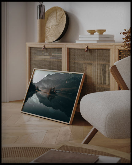 Ein Poster von einer malerischen Insel im Eibsee bei Bayern, an einer Holzkommode angelehnt und stehend auf dem Holzboden