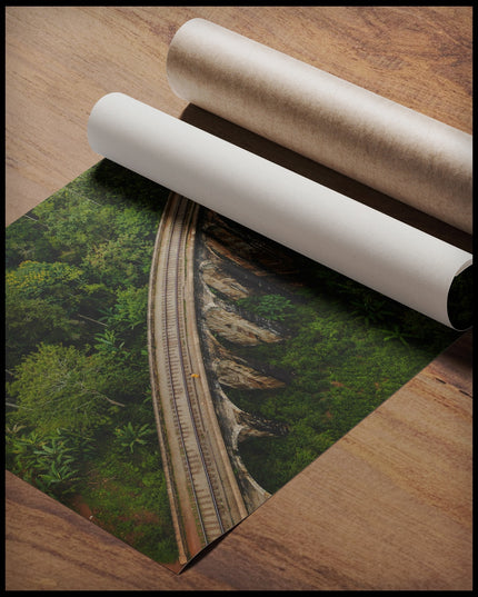 Ein Poster aus der Vogelperspektive von einer Viaduktbrücke aus Stein die durch einen tropischen Wald führt, gerollt auf einer Holzoberfläche liegend