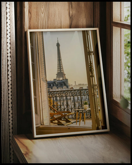 Ein gerahmtes Poster von einem Balkon in Paris mit Blick auf den Eiffelturm bei Sonnenuntergang, vor einem Fenster an die Wand angelehnt